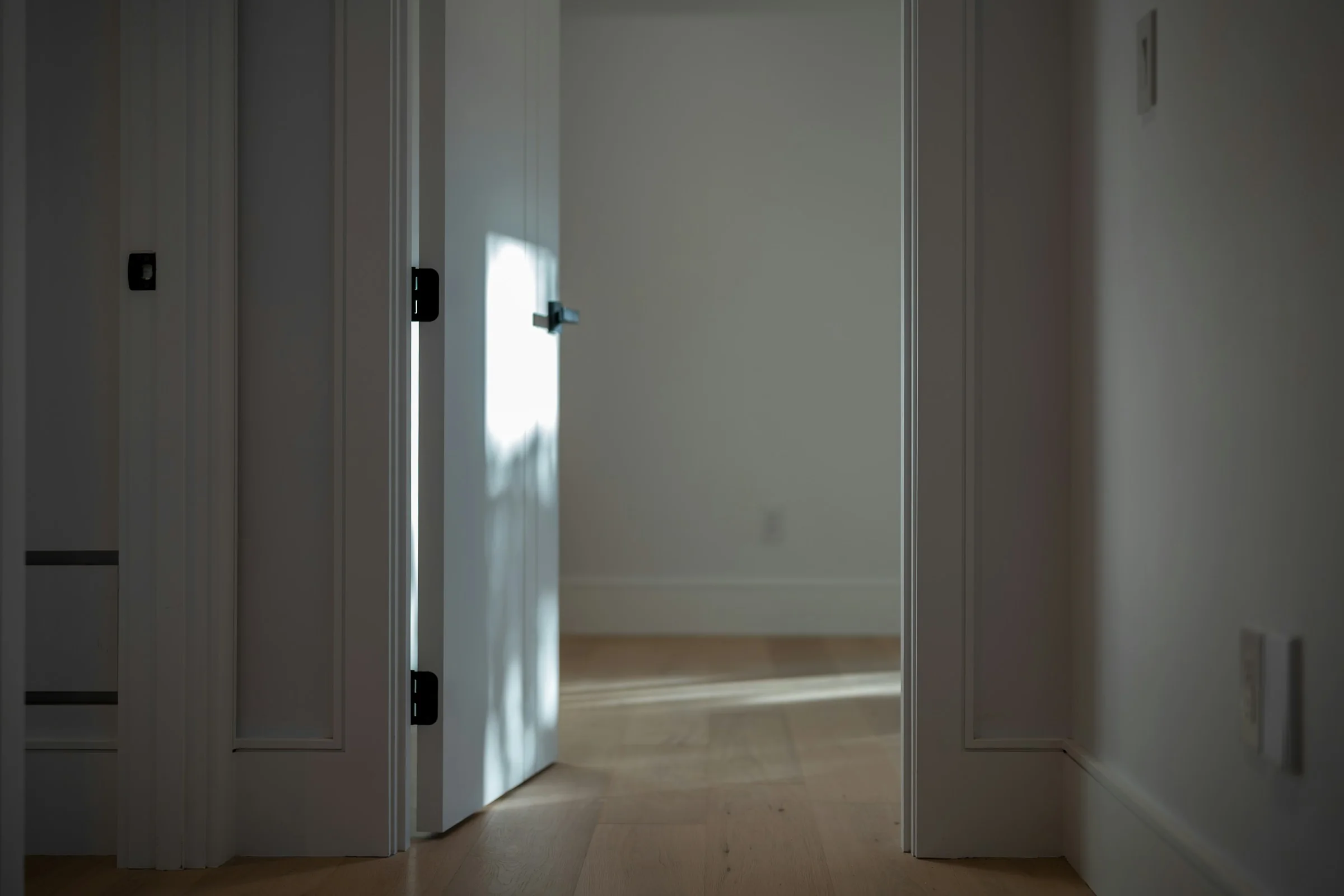 Porte blanche et sol en bois clair après remise en état